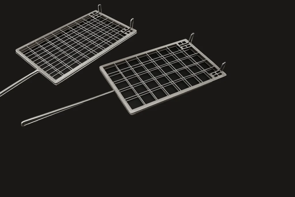 Dos rejillas rectangulares de acero inoxidable tipo lenguadera con mango largo sobre fondo negro.